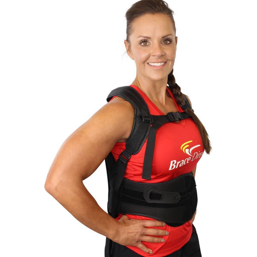 A smiling model demonstrates the fit of the black Brace Direct Posture Back Brace TLSO.