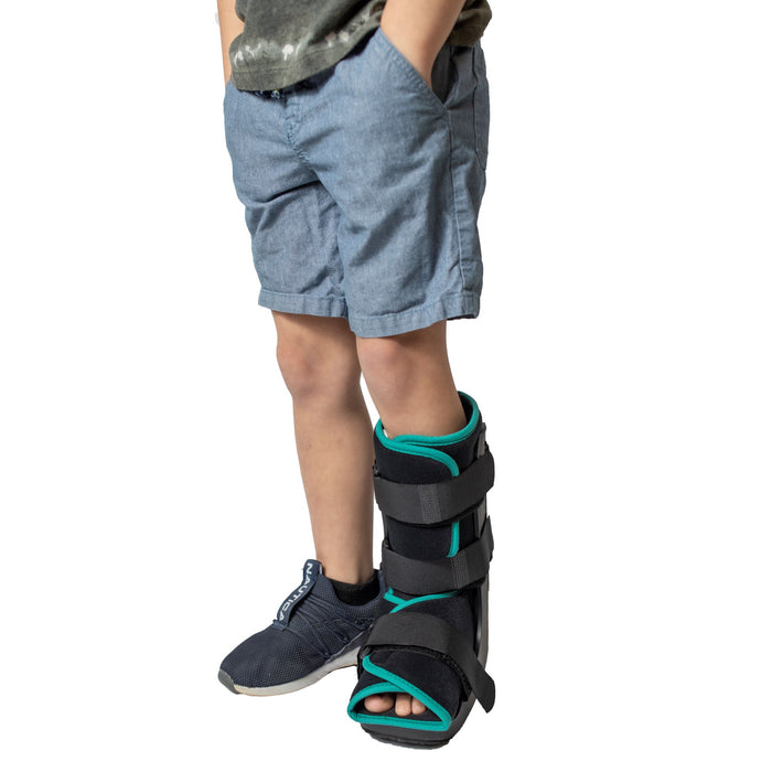 Front view of the Brace Direct Pediatric Walker Fracture Boot, worn by a boy.