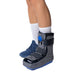 Brace Direct Short Lightweight Medical Full Shell Walking Boot with Air Pump, worn by a model.