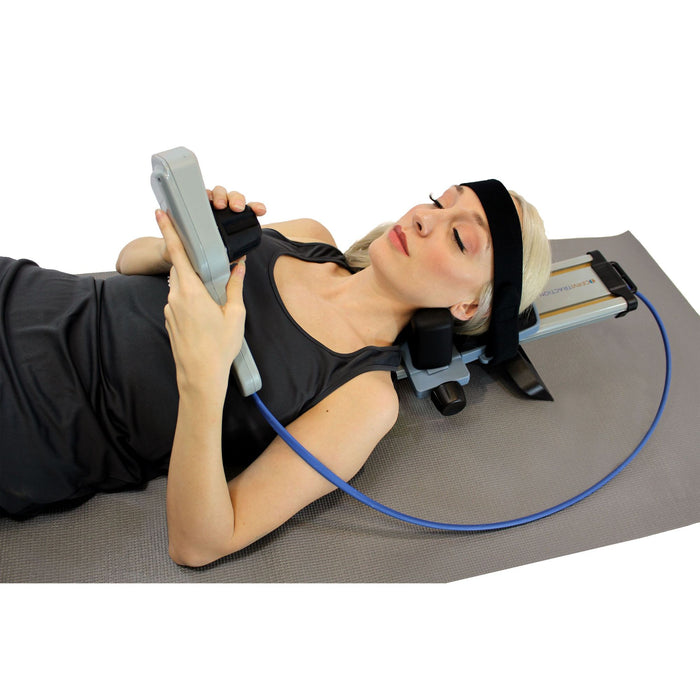 A woman reclining while operating the Brace Direct Cervical Neck Traction Unit.