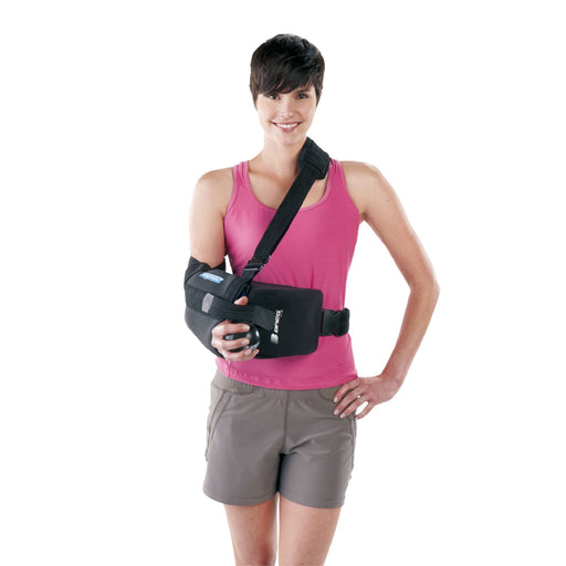 A smiling model demonstrates the fit of the Breg Slingshot Neutral Posture Shoulder Brace, by Brace Direct.