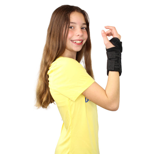 A smiling girl demonstrates the fit of the Brace Direct pediatric wrist brace.