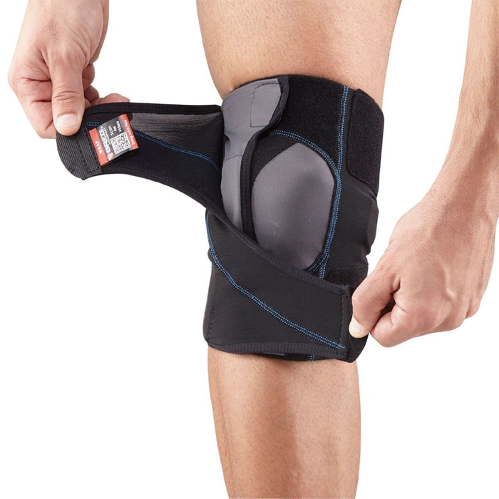 Man demonstrates how to fit the Breg FreeSport Athletic Knee Support Brace, step 3: adjust straps below and above the patella.