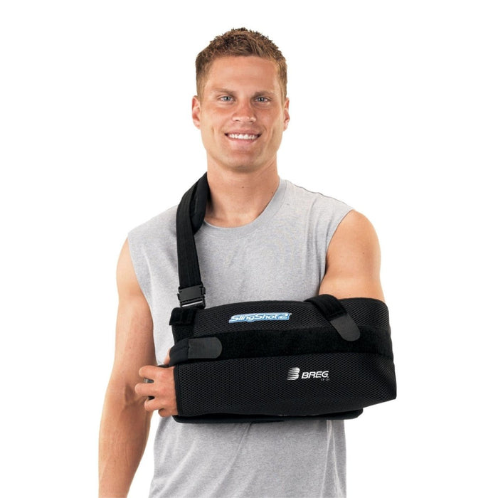 A smiling model demonstrates the fit of the Breg SlingShot 2 Shoulder Immobilization Brace, by Brace Direct.