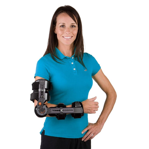 A smiling model demonstrates the fit of the Breg Telescoping Elbow Support Brace, by Brace Direct.