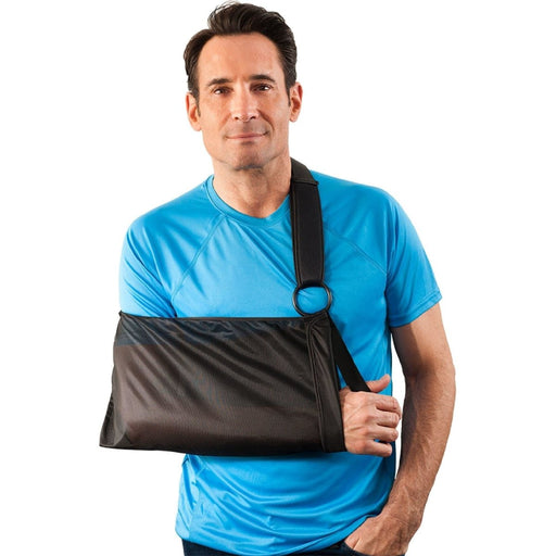 A smiling model demonstrates the fit of the Breg Universal Essential Shoulder Sling, by Brace Direct.